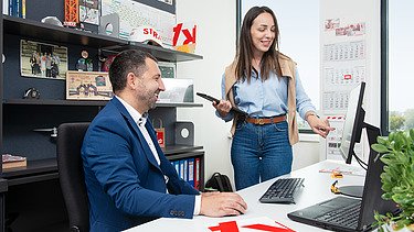 Tvoja karijera u STRABAG-u Slika muškarca i žene, žena pokazuje prema ekranu računara