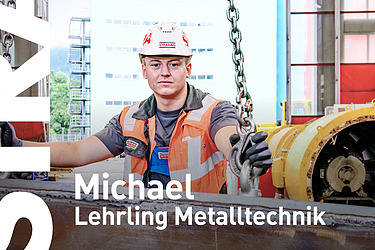 Lehrling hockt auf einer Baustelle und hält sich an einer Kette fest