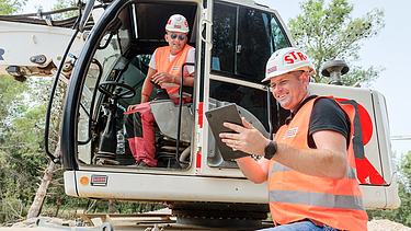 Ante pokazuje nešto na tabletu kolegi u bageru