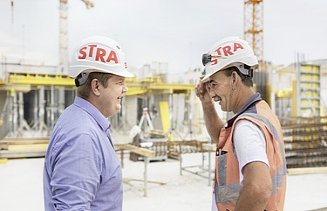 Photo Two men with helmet facing are talking at the construction site