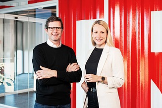 Zwei STRABAG Mitarbeiter:innen lächeln in die Kamera