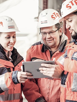 Photo Three people with helmet look at a tablet