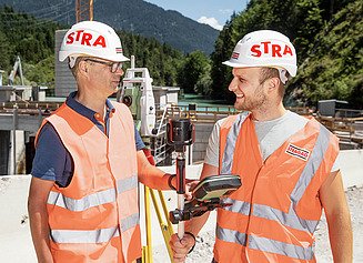 Zwei Vermessungstechniker auf der Baustelle