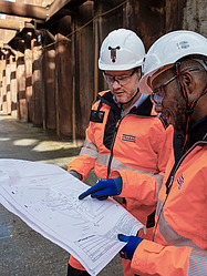 Three construction workers looking at a plan.