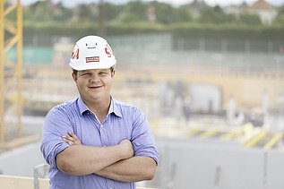 Photo man with folded arms and helmet on construction site