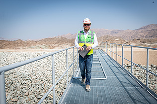 Karriere-Story Christoph Foto Mann mit Helm und Weste auf der Baustelle im Oman