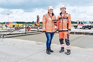 Twee collega's staan samen op de werf