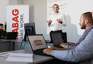 Foto Man präsentiert mit beiden Händen in einem Seminarraum