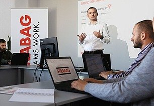 Foto Man präsentiert mit beiden Händen in einem Seminarraum