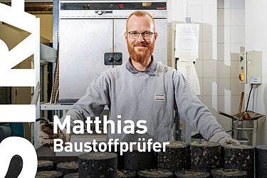 Mann sitzt mit aufgestützten Armen an einem Tisch