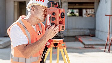Photo Man with helmet stands in front of construction pit