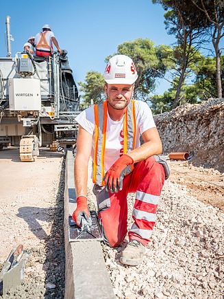 Slika zaposlenika na gradilištu kako radi rubnik