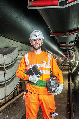 A man between two buildings smiling in the camera