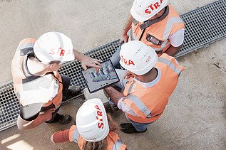 Aykut with his team on the construction site with an tablet in his hands