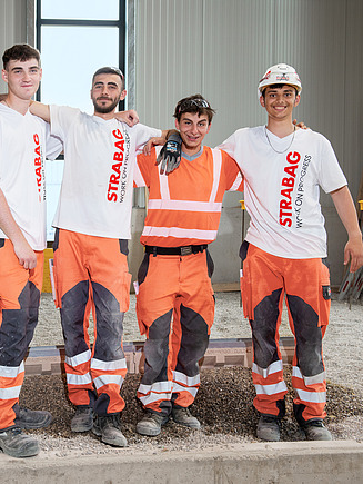Grupa 4 stażystów stojących w sali centrum szkoleniowego.