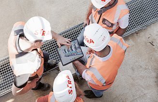 Aykut with his team on the construction site with an tablet in his hands