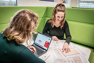 A woman stands in front of an electricity box