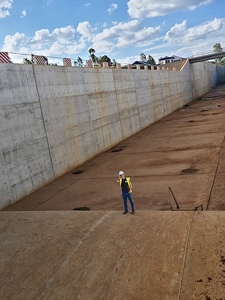 Young man in protective work clothing standing on Thiba Dam in Kenya