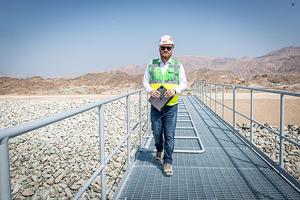 STRABAG Projektleiter steht auf einem Metallsteg und blickt in die Kamera