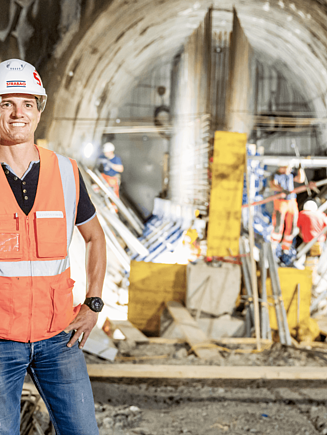 Photo of a STRABAG employee in front of a tunnel construction site