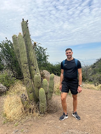 Young man standing next to cacti.
