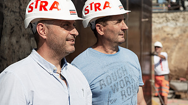 Foto Zwei Männer mit Helm schauen nach rechts oben