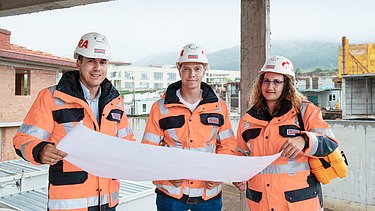 Colleagues stand together on the construction site