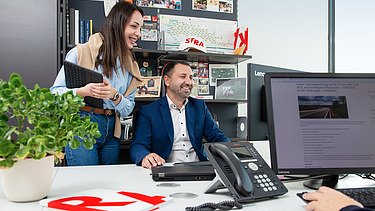 Dvoje kolega gleda u ekran i priča