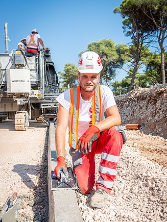 Kolega radi rubnjak na gradilištu
