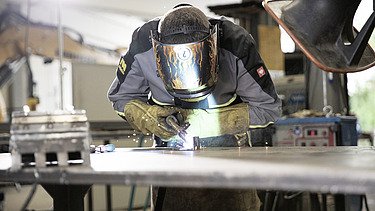 Foto Mann mit Schutzhelm schweißt