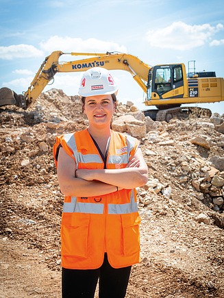 Fotografija kolegice na gradilištu, iza nje je bager