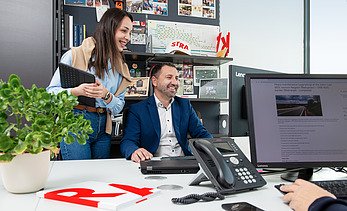 Dvoje kolega gleda u ekran i priča