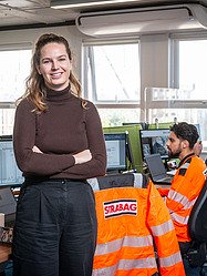 A woman in the office standing in front of a table