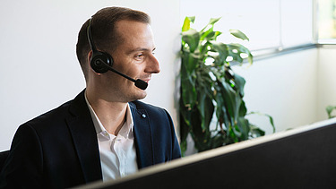 Photo man with head set sitting at screen