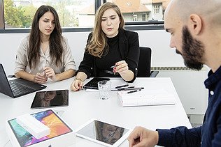 Marija sitting with her team around a table