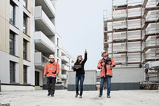 Photo 3 people at construction woman pointing up