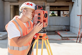 Photo Man with helmet stands in front of construction pit