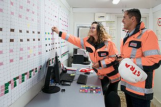 Three colleagues discuss together on the construction site in Oman