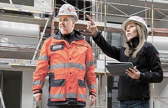 Photo Two people on construction site woman pointing up left