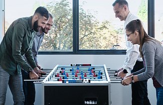 Photo Four people at soccer table table football