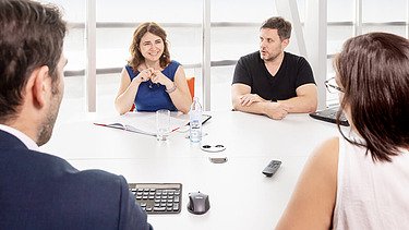 Four people discuss legal issues in a meeting