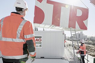 Photo Two men back view watching container elevation