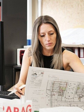 Photo technician in office looks at plan
