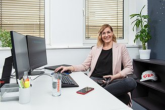 Marion, IT-Softwareentwicklerin bei STRABAG, an ihrem Schreibtisch sitzend im Büro