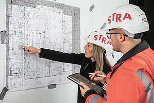 Photo Woman pointing at plan Man looking at plan