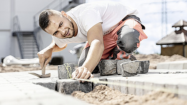 Foto: Marcel beim Verlegen von Pflastersteinen