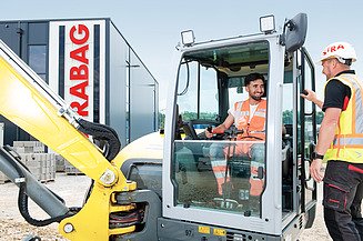 Mladenič na gradbišču gleda v kamero