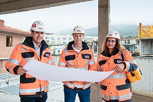 Colleagues stand together on the construction site