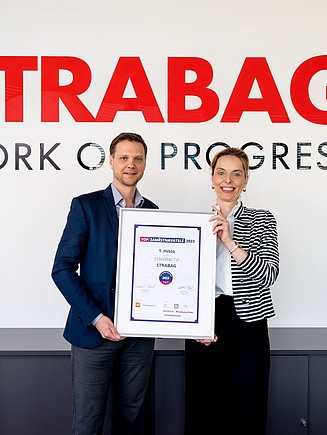 Shot of two employees in front of the screen during a meeting