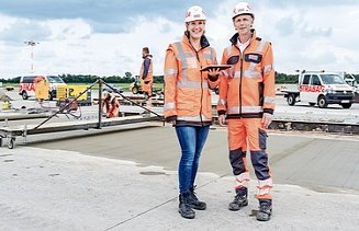 Twee collega's staan samen op de werf